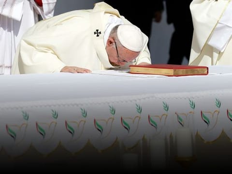 Pope Francis bows on the altar as he celebrates a mass at the Zayed Sports City Stadium in Abu Dhabi. 