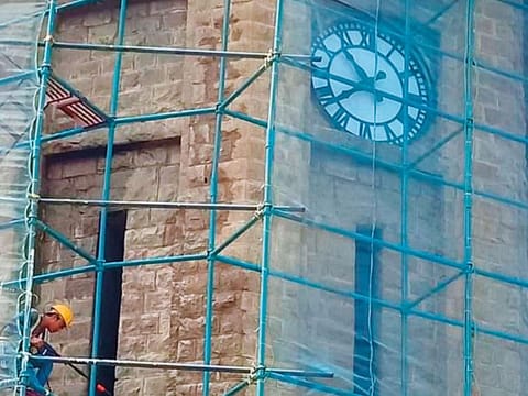 A worker is seen during restoration of the clock tower at Moazzam Jahi Market.
