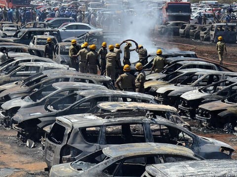 Firefighters extinguish smouldering cars after a fire broke out in a parking lot during the Aero India show at the Yelahanka Air Force Station in Bengaluru, India, February 23, 2019. 