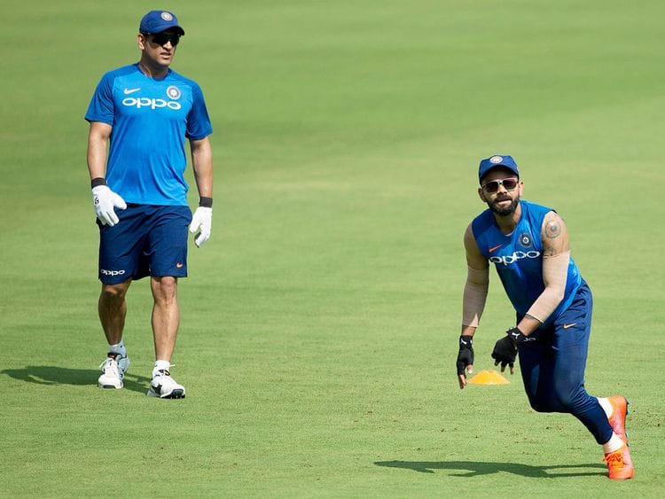 Mahendra Singh Dhoni, left, watches Virat Kohli