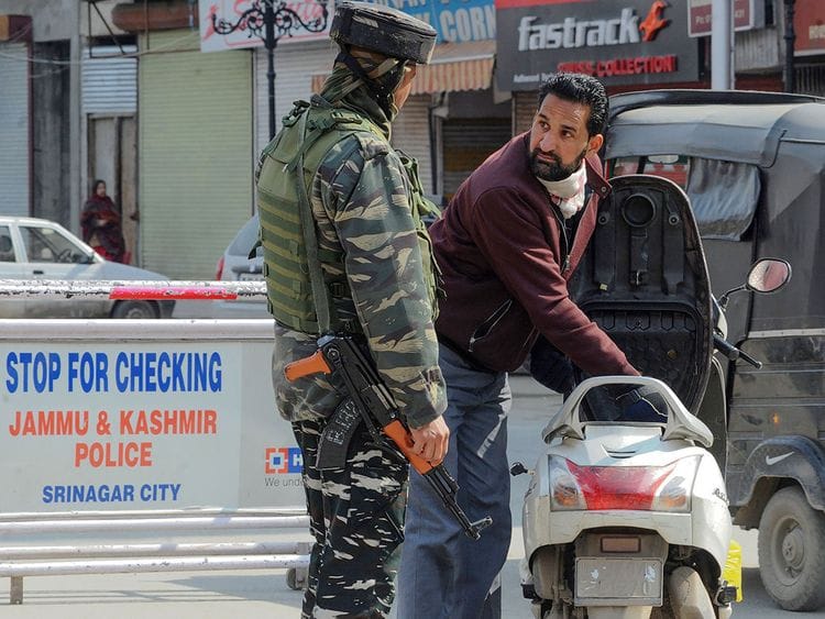 An Indian Central Reserve Police Force (CRPF) personnel searches