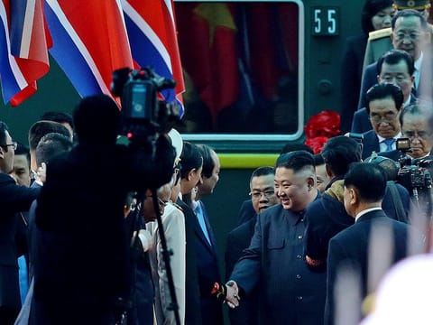 North Korean leader Kim Jong Un, center right, is welcomed upon arrival by train, back, in Dong Dang in Vietnamese border town 
