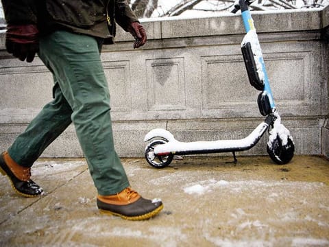 A person walks past a sharable electric scooter during winter weather on February 20 in Washington, DC.