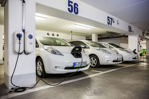 Electric automobiles charge in a parking lot in Berlin.  