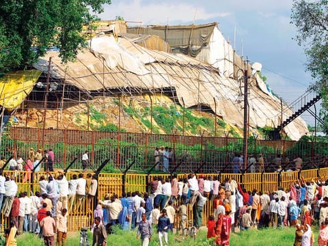 In this July 5, 2005 file photo, people look through a fence in Ayodhya, in the northern Indian state of Uttar Pradesh.