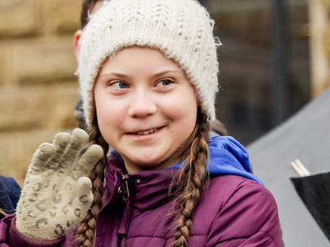 Swedish climate activist Greta Thunberg waves on stage during a demonstration of students calling for climate protection on March 1, 2019 in front of the cityhall in Hambourg, Germany.