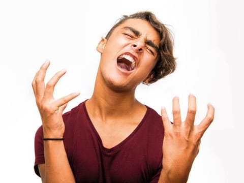 Young man shouting with negative facial expression. 