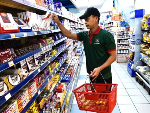 A grocery employee prepares for a delivery order.