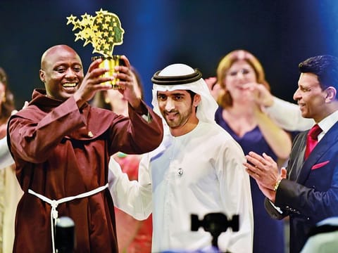 Shaikh Hamdan presents the Best teacher award to Peter Tabichi, a Maths and Physics teacher from Kenya, as  Sunny Varkey, founder of the GESF, looks on.