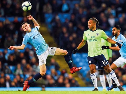Manchester City's English midfielder Phil Foden (L) reacts as he vie with Cardiff City's English striker Bobby Reid (2R) during the English Premier League football match between Manchester City and Cardiff City at the Etihad Stadium in Manchester, north west England.
