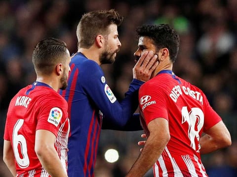Atletico Madrid's Diego Costa clashes with Barcelona's Gerard Pique.