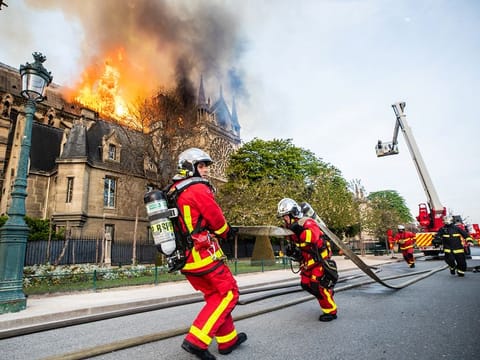 Paris fire brigade members work outside the Notre Dame-Cathedral, after the fire broke out. 