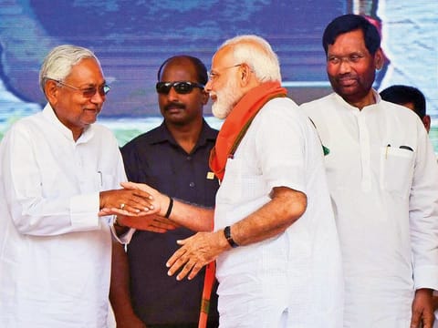 Prime Minister Narendra Modi shakes hands with Bihar Chief Minister and Janta Dal United President Nitish Kumar as Lok Janshakti Party (LJP) chief Ram Vilas Paswan looks on, during an election rally at Araria lok sabha constituency, in Forbesganj, on Saturday, April 20, 2019. 