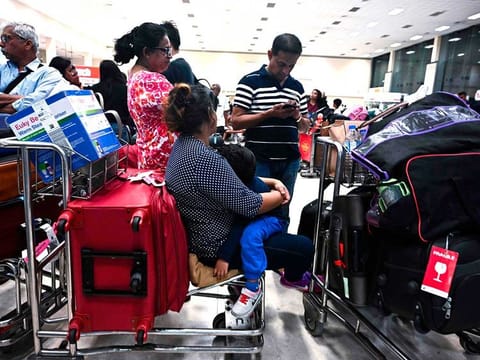 Passengers wait inside the arrival hall at Bandaranaike International Airport in Katunayake