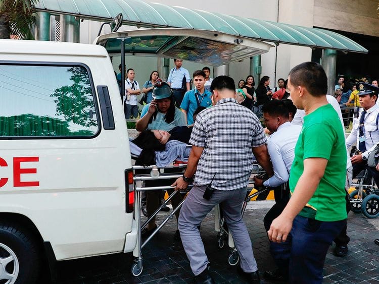 Rescue workers carry a woman to an ambulance