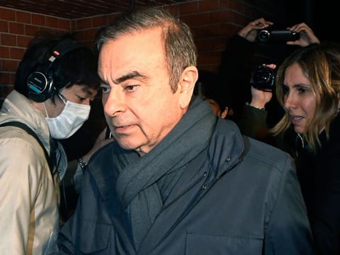 In this April 3, 2019, photo, former Nissan Chairman Carlos Ghosn, center, returns to his residence in Tokyo.