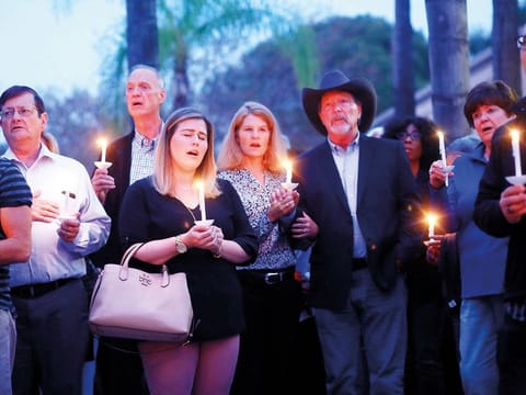 Mourners, including Poway Mayor Steve Vaus (hat) and his wife Corrie, participate in a candle light vigil for the victims of the Chabad of Poway Synagogue shooting at the Rancho Bernardo Community Presbyterian Church on April 27, 2019 in Poway, California. 