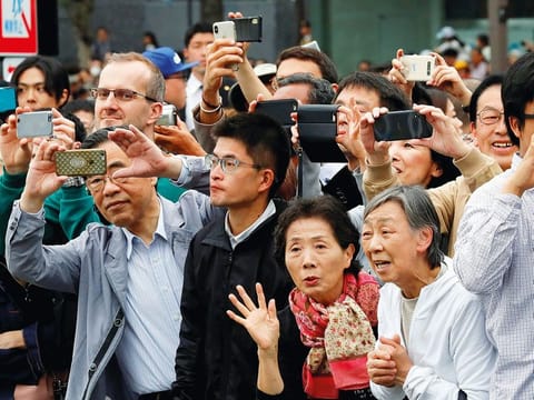 People take pictures as the Japanese royal family arrives at the Imperial Palace in Tokyo, Japan May 1, 2019.