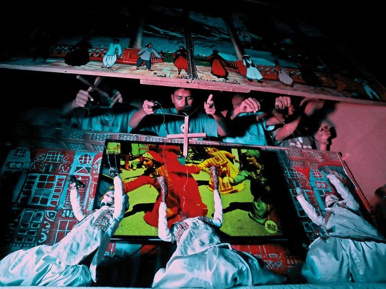 Artists play string puppets during a show in a puppet theatre in Karachi