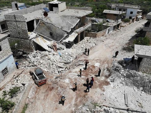 Members of the Syrian Civil Defence (White Helmets) clear rubble to open a road following reported shelling on the village of Ibdita in the Idlib province on May 8, 2019.