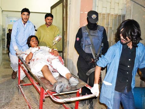 Volunteers rush an injured victim of bombing to a hospital on Monday after a powerful bomb attached to a motorcycle exploded at a mosque in Quetta, the capital of Balochistan province.