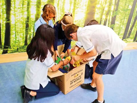 KG to Secondary students of Uptown School, Dubai, filling boxes with donated items for the Ramadan Box Project.
