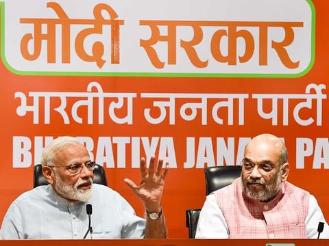 Prime Minister Narendra Modi speaks as BJP President Amit Shah looks on during a press conference at the party headquarter in New Delhi, Friday, May 17, 2019. 