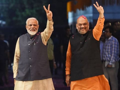 Prime Minister Narendra Modi and president of BJP Amit Shah gesture as they celebrate the victory in India's general elections, in New Delhi. 