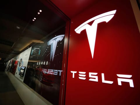File photo: A sign bearing the company logo is displayed outside a Tesla store in Cherry Creek Mall in Denver.