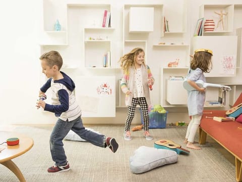  Children playing in a room with Alexa in the centre.