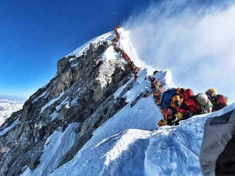 In this file handout photo taken on May 22, 2019 and released by climber Nirmal Purja's Project Possible expedition shows heavy traffic of mountain climbers lining up to stand at the summit of Mount Everest.  