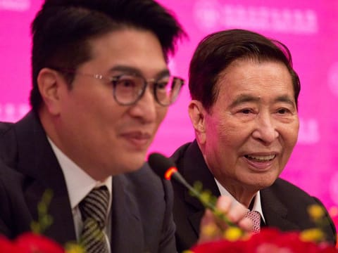 Henderson Land Development's founder and chairman Lee Shau-kee, right, and his son Martin Lee Ka-shing speaks during a news conference as Lee Shau-kee announces his retirement after the company's general meeting in Hong Kong.