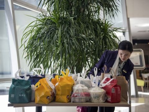 At rush hour, delivery services leave takeout orders in the lobbies of office buildings to save time, in Beijing