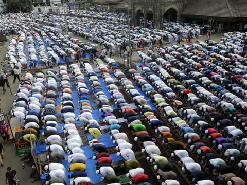 Muslims offer Eid Al Fitr prayers outside a train station in Mumbai, on Wednesday, June 5, 2019.
