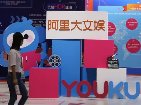 A woman walks past signs of Alibaba Culture and Entertainment Group and video-streaming platform Youku, at the recent Beijing International Cultural and Creative Industry Expo. Alibaba has ridden a surge in Chinese online commerce alongside an increasingly affluent middle-class.