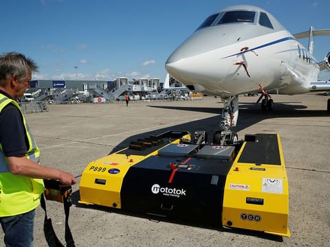A technician uses a Mototok' s high-tech aircraft tug to move a Guflstream G550 jet on the static display, before the opening of the 53rd International Paris Air Show at Le Bourget Airport near Paris, France.