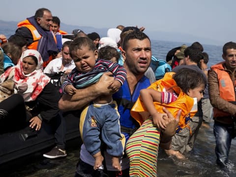 Syrian refugees arrive aboard a dinghy after crossing from Turkey to the island of Lesbos, Greece, on September 10, 2015. 