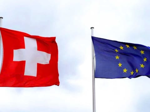 An EU flag flies beside Switzerland's national flag near the German-Swiss border in Rheinfelden, Germany.