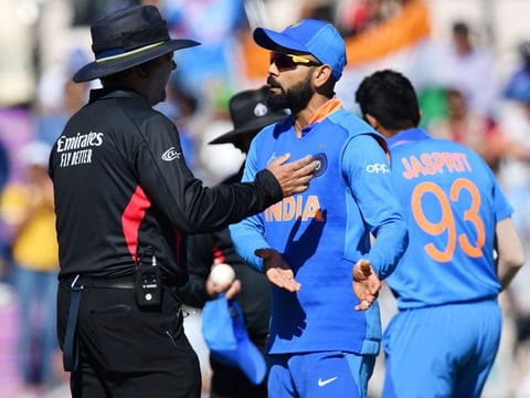 India's captain Virat Kohli (C) speaks with the umpire during the World Cup group stage match against Afghanistan at the Rose Bowl in Southampton. 