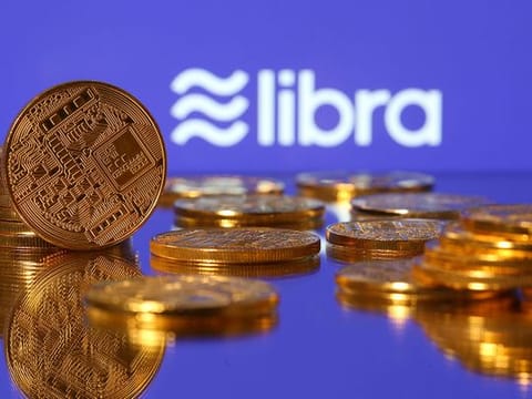 Representations of virtual currency are displayed in front of the Libra logo in this illustration picture. 
