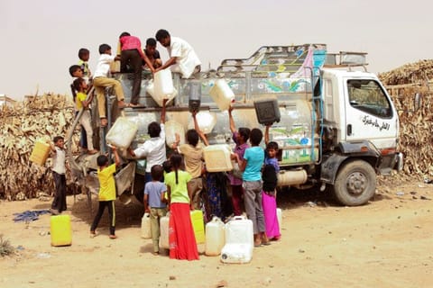 Displaced Yemenis from Hodeida fill jerrycans with water at a make-shift camp in the northern district of Abs in the country's Hajjah province, on June 23, 2019. 