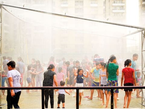 Residents of a housing society cool off with a "rain dance" organized to beat the heat on a hot summer day in Greater Noida, outskirts of New Delhi, India.