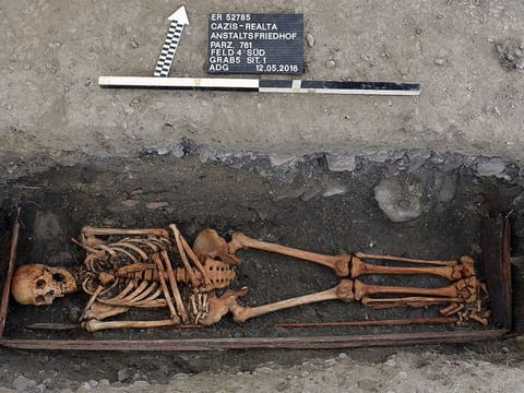 This handout picture released by the Archeology service of the Swiss canton of Graubunden shows a skeleton in a grave, part of a total of 103 graves dating from the 19th and 20th centuries discovered during the construction of Realta new penitentiary building in Cazis. 