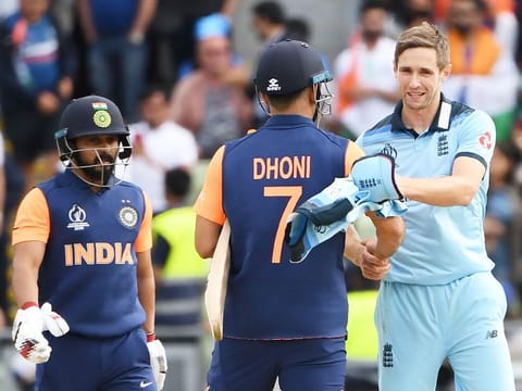 England's Chris Woakes (R) shakes hands with India's Mahendra Singh Dhoni (C) and Kedar Jadhav (L) after the match at Edgbaston in Birmingham. 