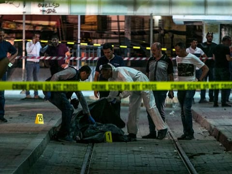 Tunisian forensic experts work on the scene after police shot at a man wanted for terrorism in Al Intilaka, near Tunis, Tunisia.