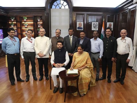 Indian Finance Minister Nirmala Sitharaman, seated right, signs the Indian federal budget after giving final touches, as Indian junior Finance Minister Anurag Thakur, seated left, watches along with finance budget team at her office in New Delhi, on Thursday, July 4, 2019.  
