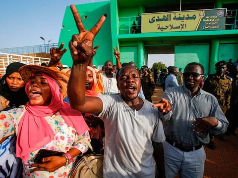 A Sudanese man flashes the victory gesture as people gather outside al-Huda prison in the capital Khartoum's twin city of Omdurman on July 4, 2019, during a ceremony marking the release of 235 members of a faction of the Sudan Liberation Army, which has fought government forces in war-torn Darfur. 