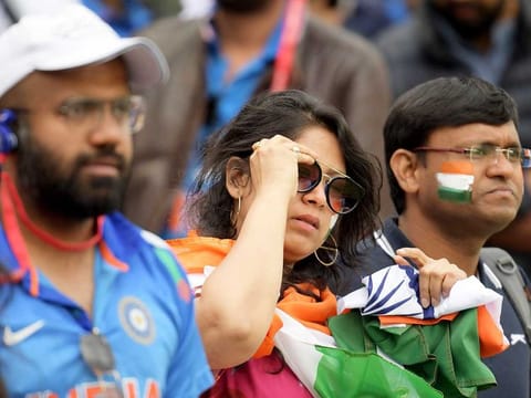 India fans react at the end of play during the Cricket World Cup first semi-final against New Zealand at Old Trafford in Manchester. 