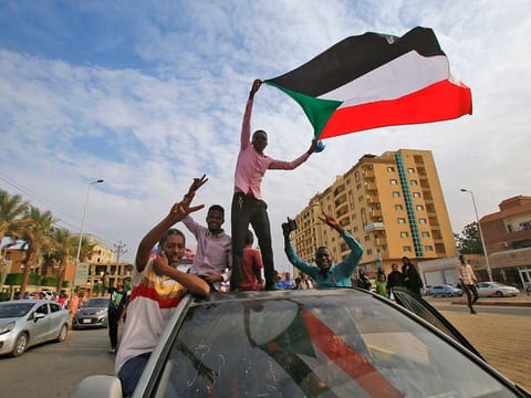  Sudanese protesters wave their national flag (File image)
