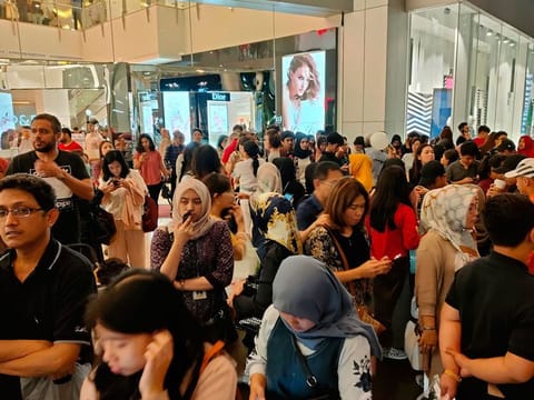 People stand outside a shopping mall following an earthquake in Jakarta, Indonesia, Friday, Aug. 2, 2019. A strong earthquake struck off the coast of Indonesia's Java island on Friday, swaying buildings as far away as the capital and prompting national authorities to urge those in coastal areas to head to higher ground in case of a tsunami. 
